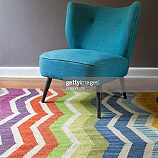 Doppelter Nutzen - Single Blaugrün Sessel und farbige chevron-Muster Teppich innen - Stock-Fotografie