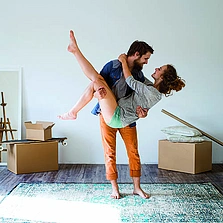Moderne Fertigung - Mann trägt Frau in seine Arme, Umzug in neues Haus. - Stock-Fotografie